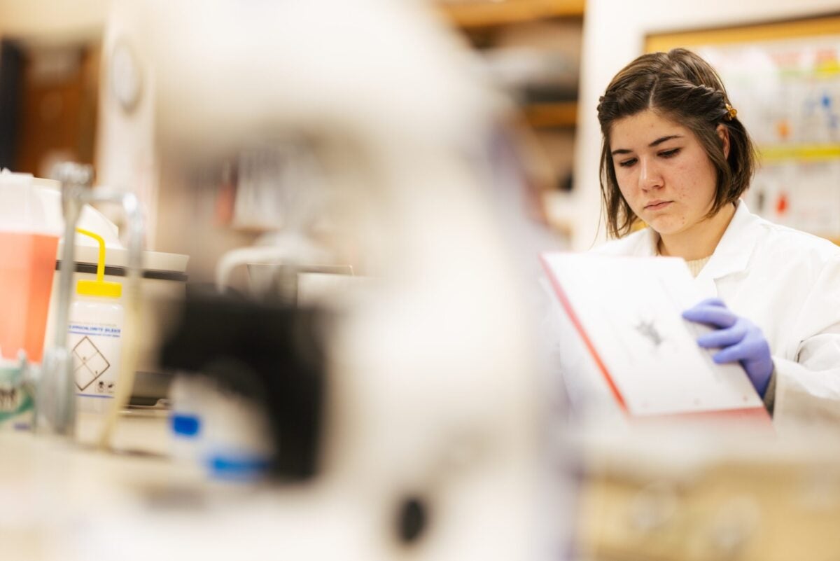 student reading a book in a lab
