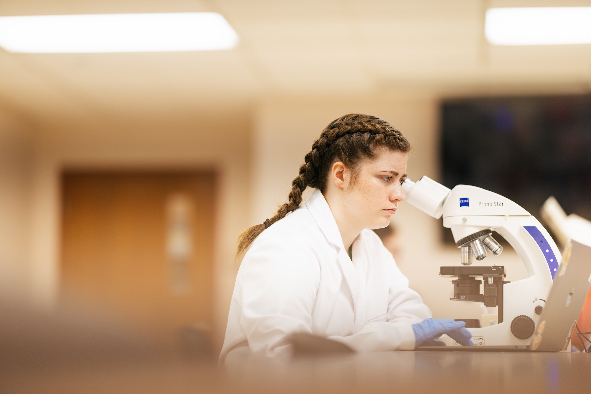 student looking through a microscope