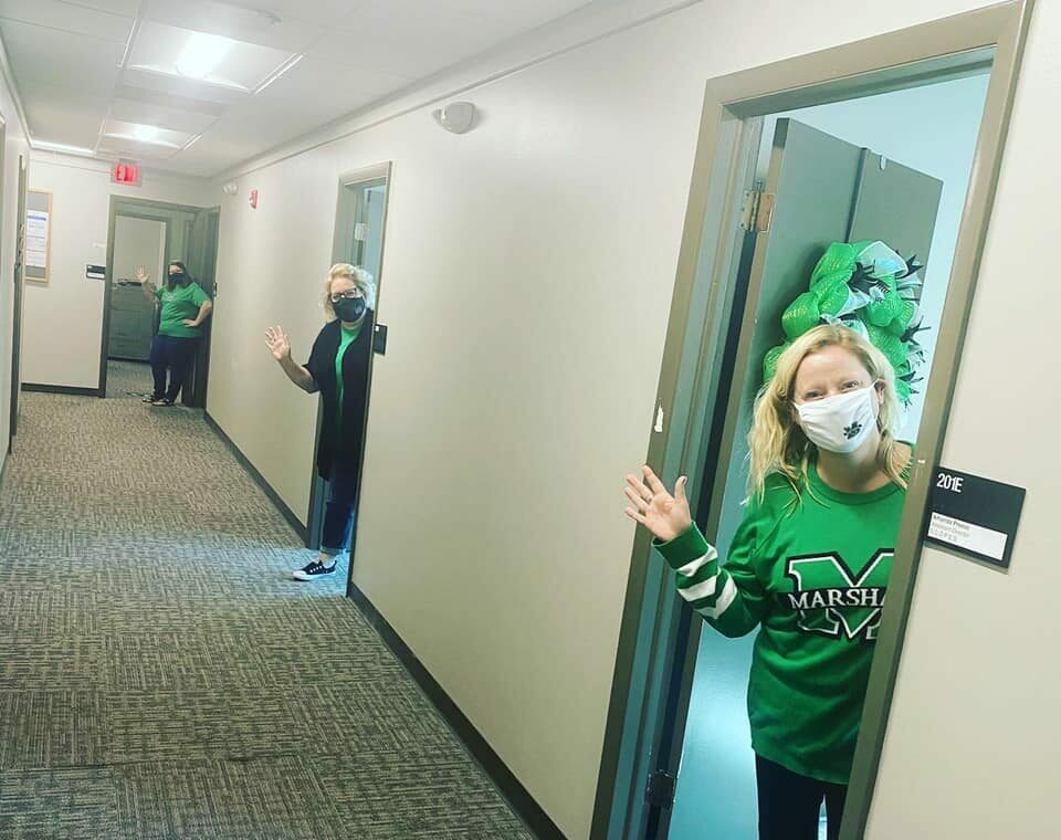 three people waving from their office doors