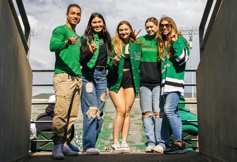 Students smile together while entering Joan C. Edward's Stadium at Marshall University