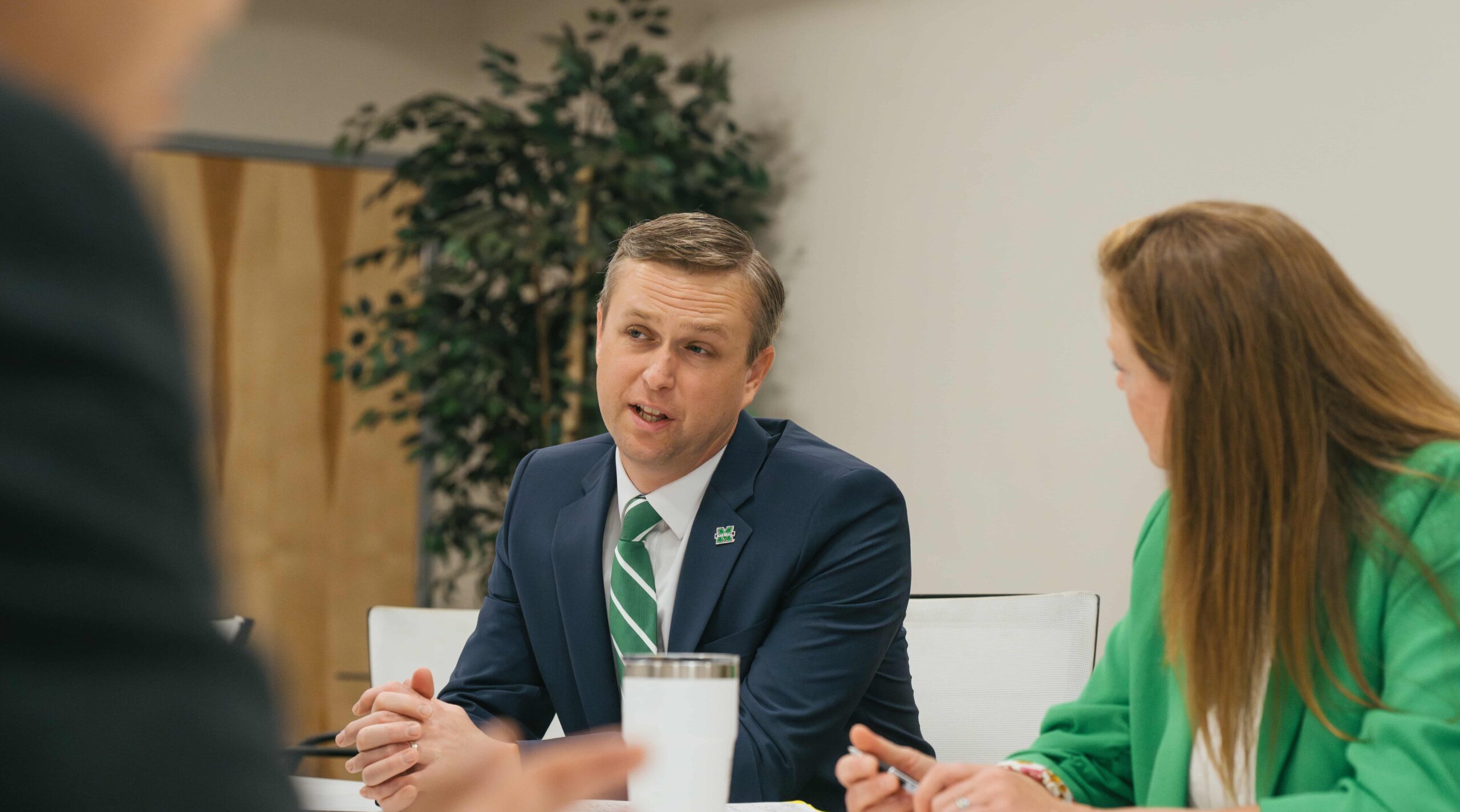 three people sitting at a table talking