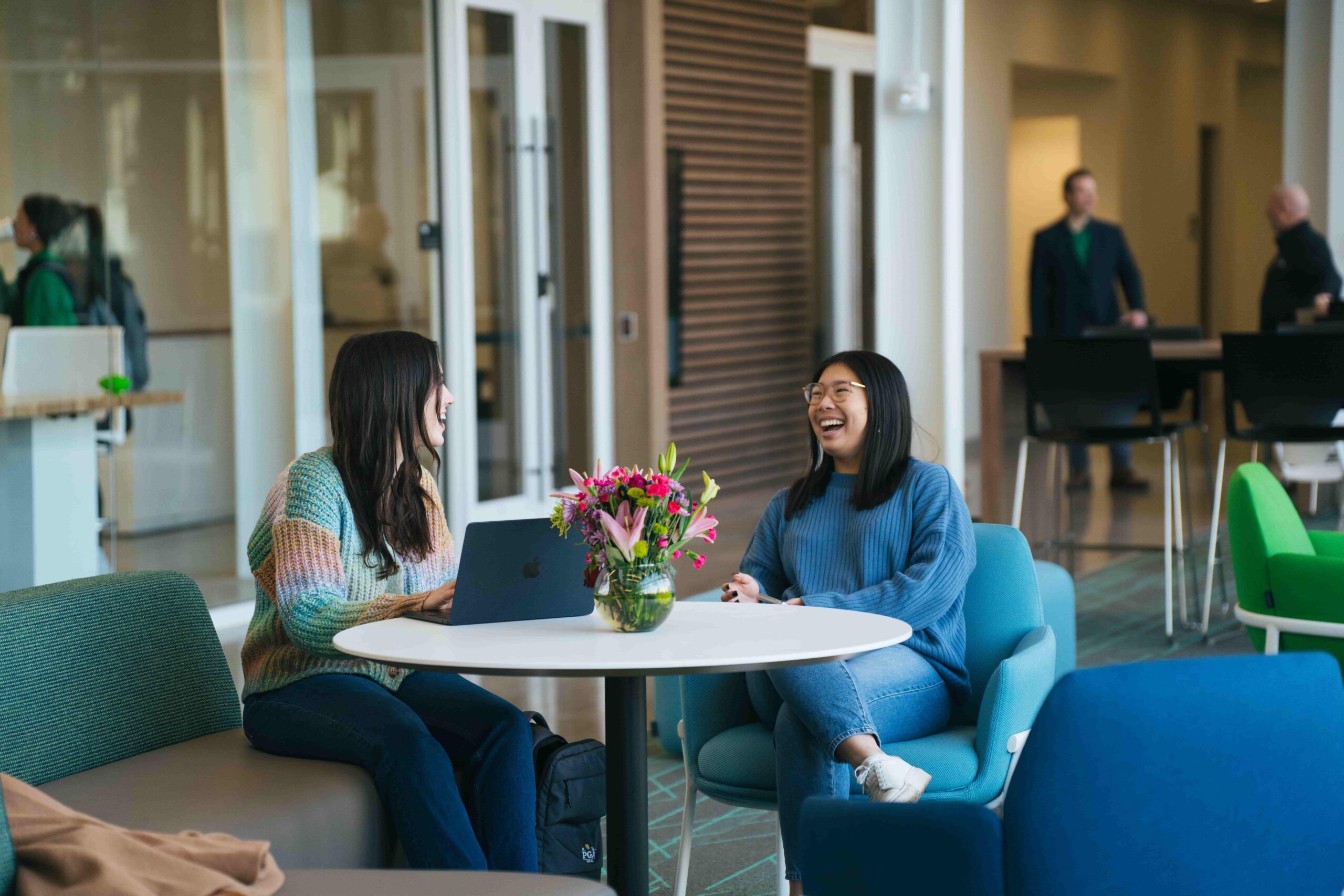 two students laughing inside the college of business building