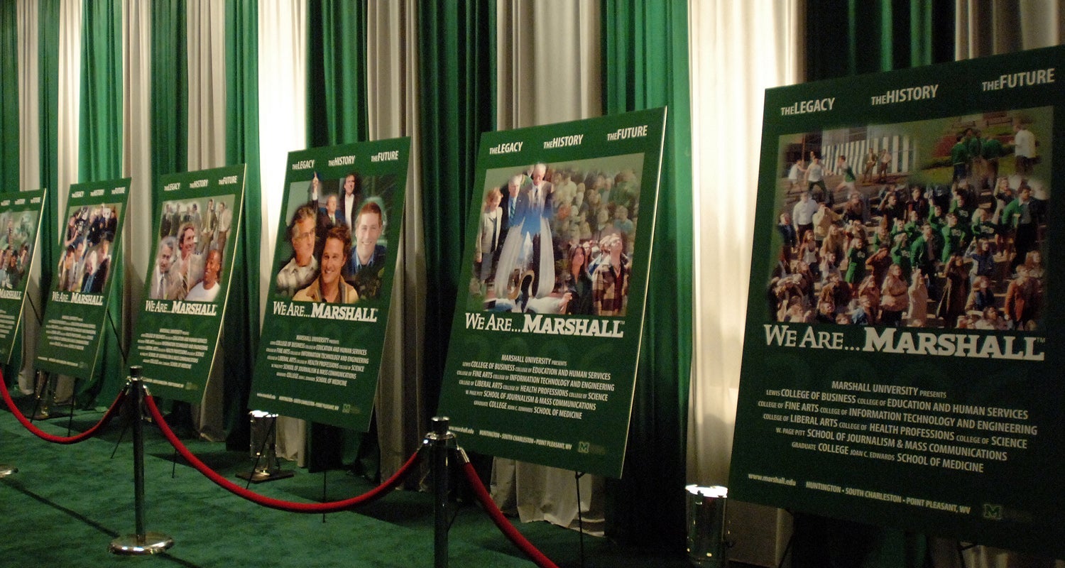 A series of We Are... Marshall movie posters line the green carpet at the movie premiere celebration