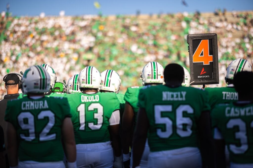 football players from the sidelines looking at the crowd