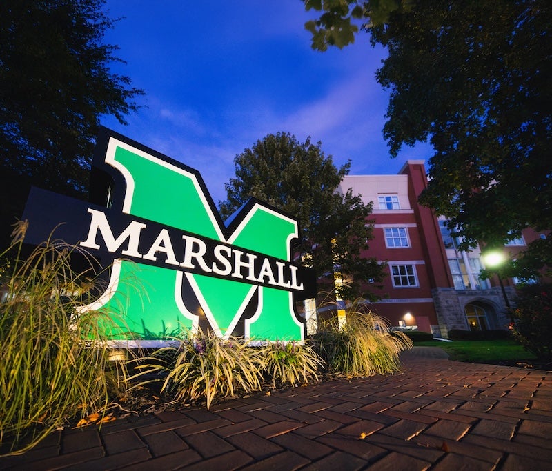 M sign lit up at night.
